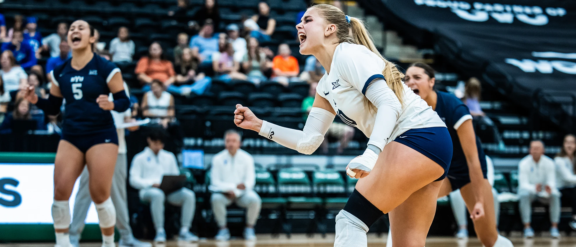 BYU women's volleyball player shouting in celebration after a point during a 2026 Big 12 road match