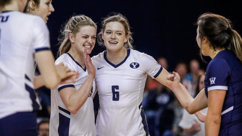 BYU volleyball players smiling together between points during a 2026 schedule home match