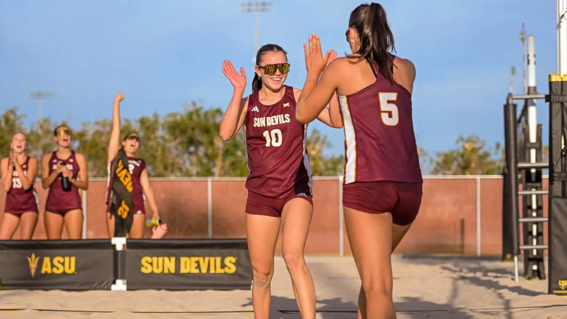 Arizona State Sun Devils volleyball teammates high-fiving after winning a point in Tempe