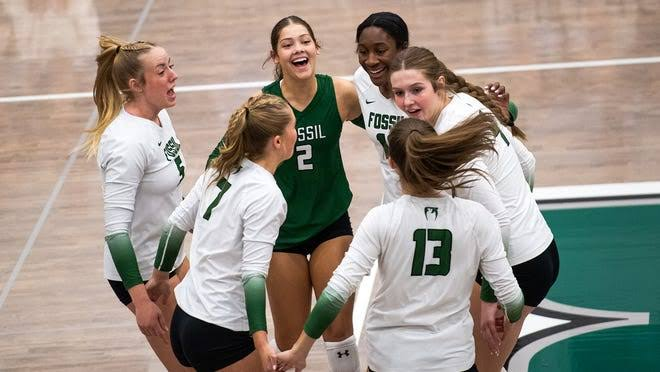 Colorado volleyball players celebrating together in a green and white huddle after winning a point