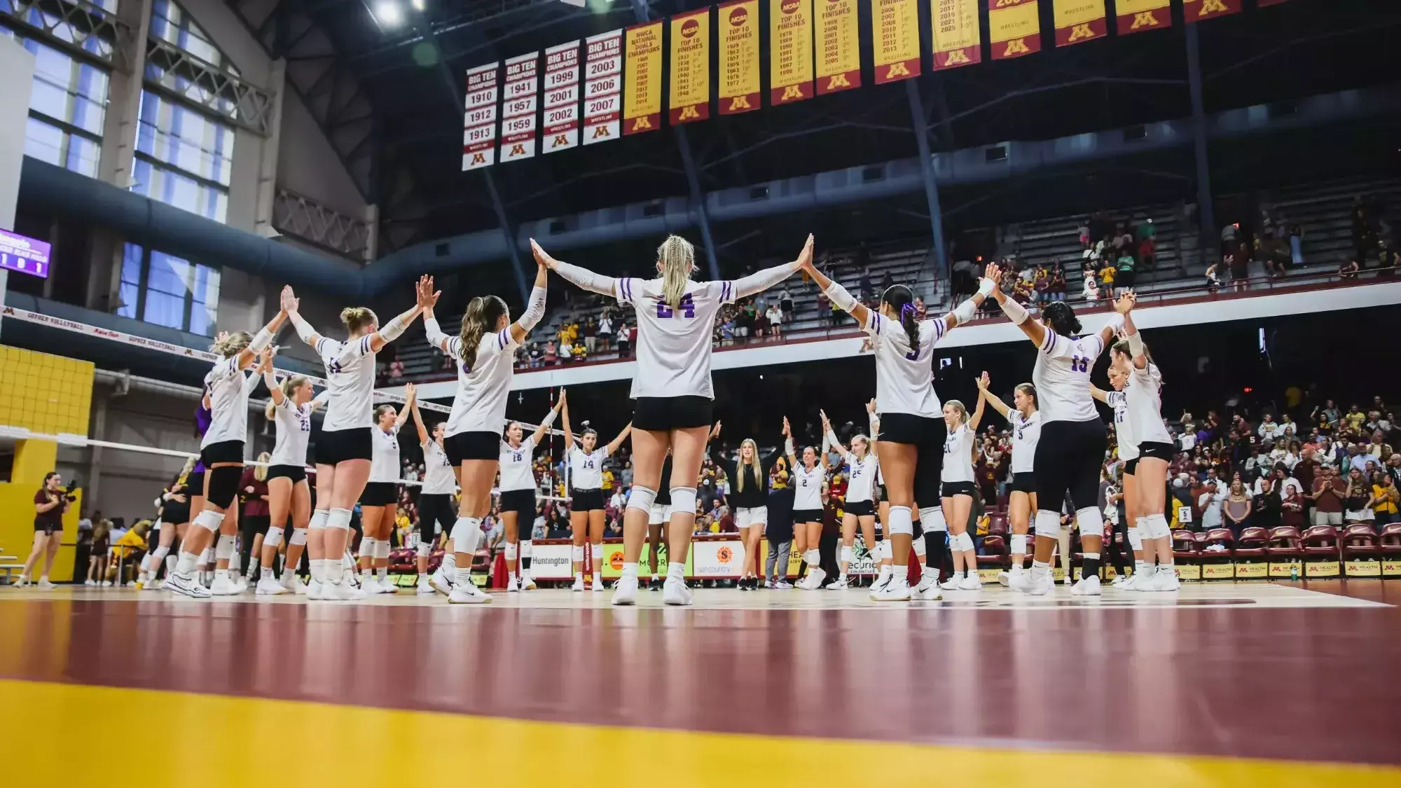 Iowa State Cyclones volleyball team high-fiving during starting lineups at an NCAA Tournament match in Minneapolis