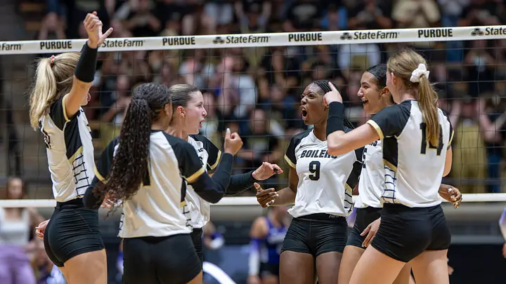 Purdue Boilermakers volleyball players celebrating a point at the net during a 2026 season home match at Holloway Gymnasium