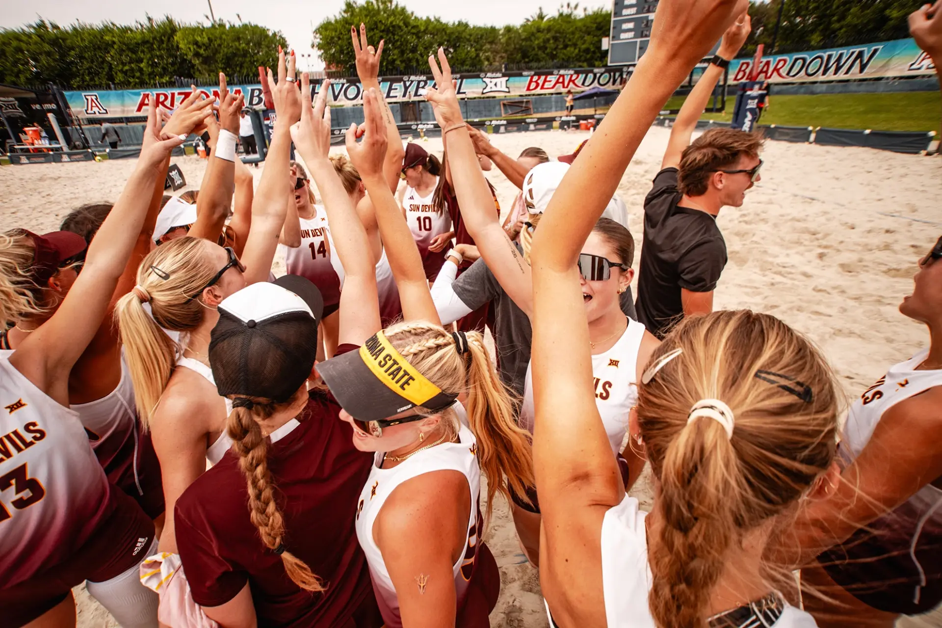 Arizona State Sun Devils volleyball team huddling with hands raised before a 2026 season match