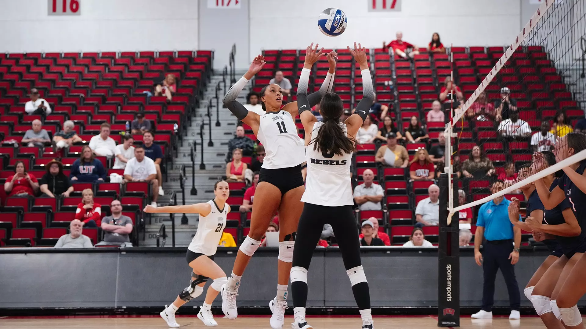 UNLV Lady Rebels volleyball player number 11 setting the ball at the net during a home match at Cox Pavilion