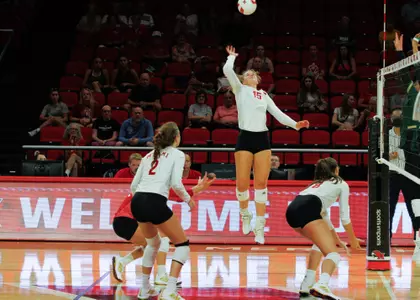 Miami volleyball player rising for a swing in front of the Welcome banner during a 2026 schedule match