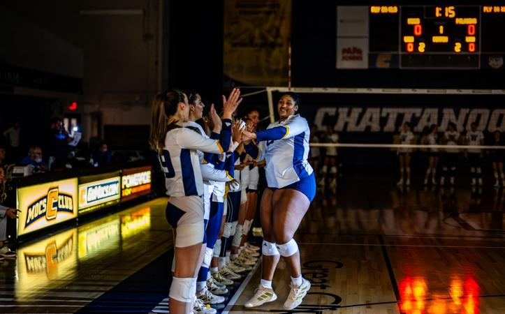 Tennessee volleyball player high-fiving teammates during starting lineup introductions at a road match in Chattanooga