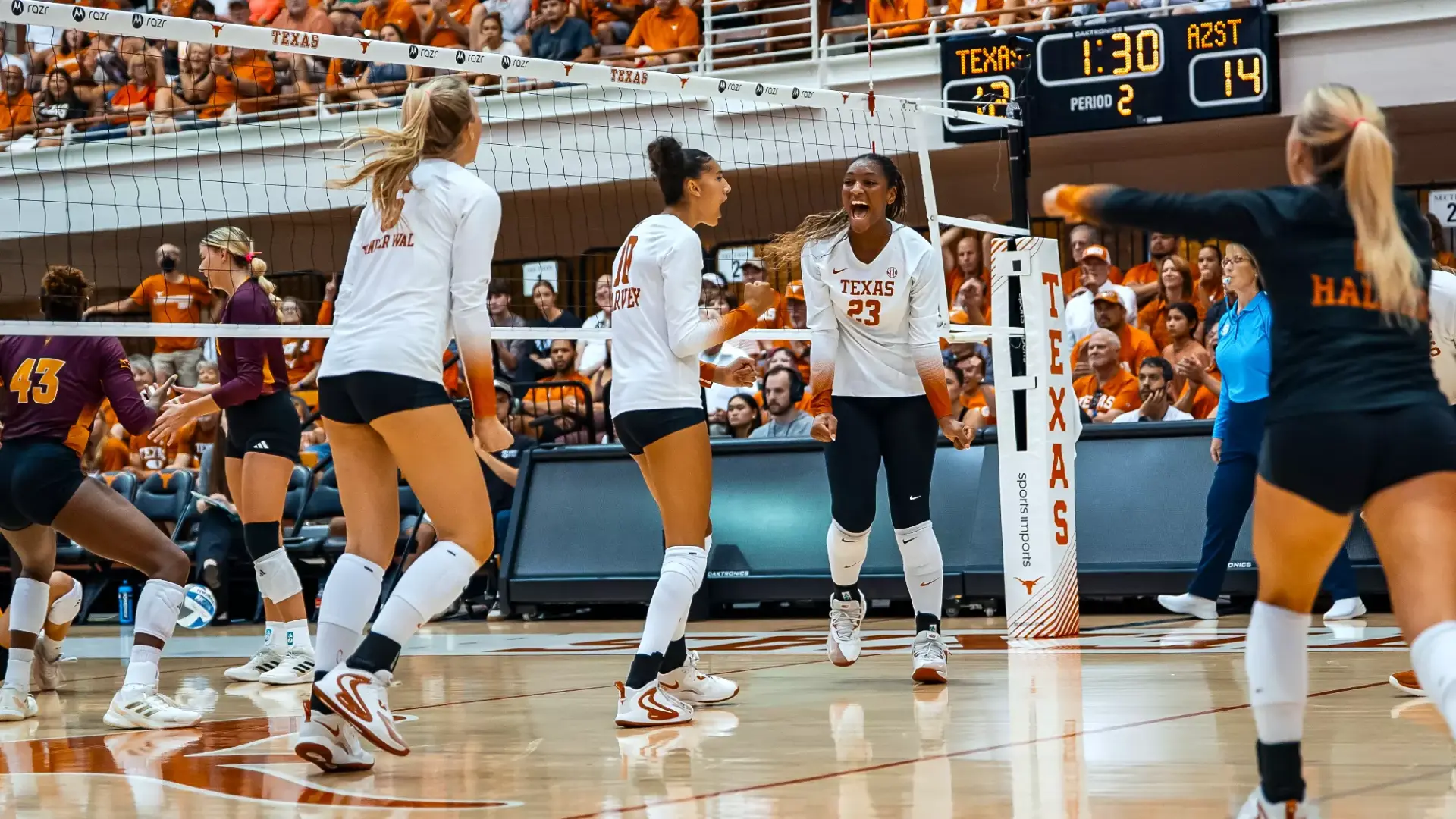 Texas Longhorns volleyball players celebrating a point at Gregory Gymnasium during the 2026 season