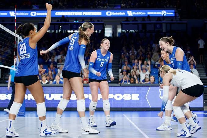 Kentucky volleyball players celebrating a point together during a 2026 home match