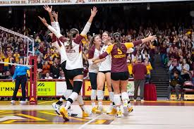 Minnesota Golden Gophers volleyball players celebrating with arms raised in front of a packed Maturi Pavilion crowd during the 2026 season