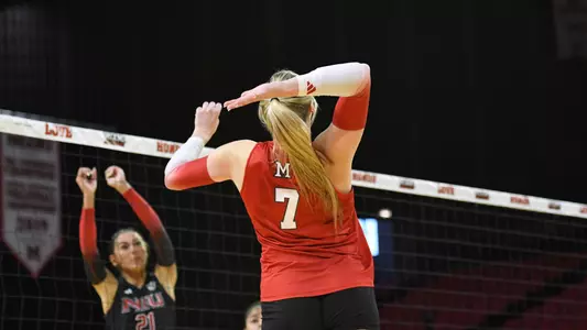 Miami volleyball player number 7 celebrating a kill in front of a red home crowd