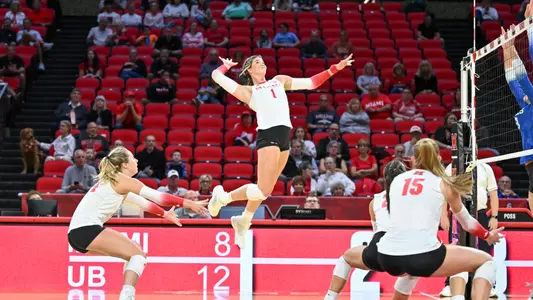 Miami volleyball outside hitter jumping for an attack while teammates cover the court
