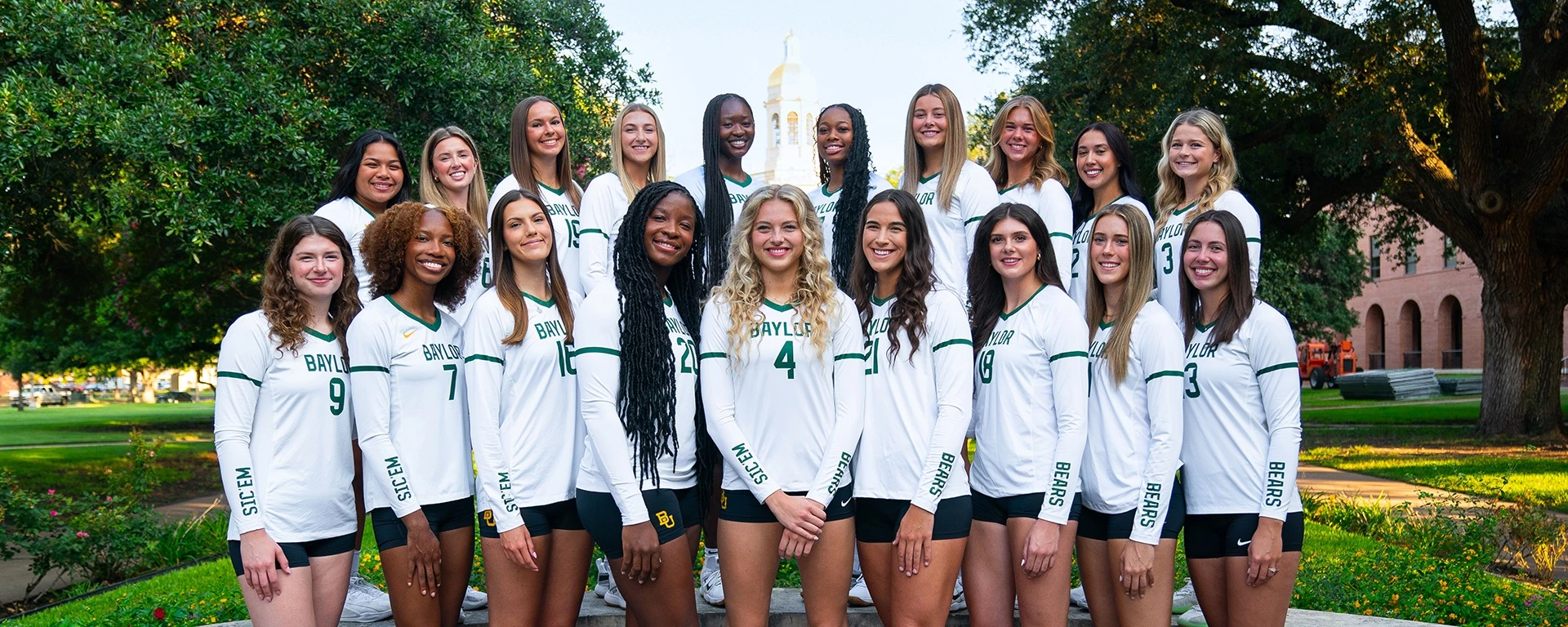 Baylor Bears volleyball 2026 team photo in white jerseys on the Waco campus with Pat Neff Hall in the background