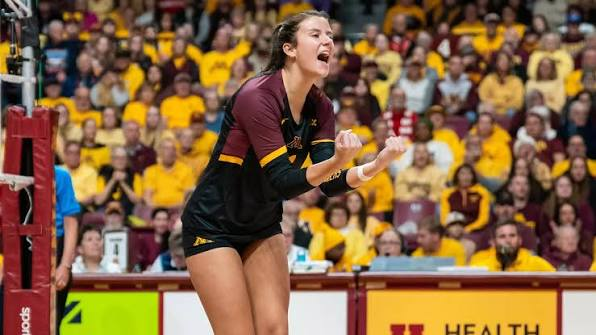 Minnesota Gophers volleyball player shouting in celebration at the net during a 2026 schedule home match