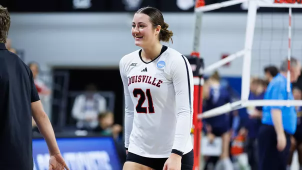Louisville Cardinals volleyball player number 21 smiling during an NCAA Tournament match