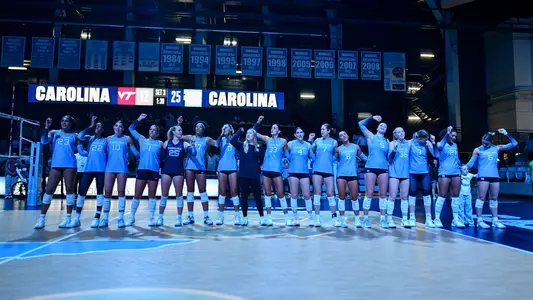 North Carolina Tar Heels volleyball team lined up arm-in-arm at Carmichael Arena after a 2026 season win
