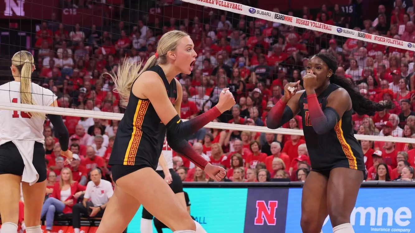 USC volleyball players celebrating a point at the net during a road match against Nebraska in 2026