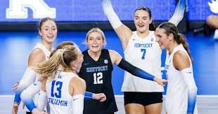 Kentucky Wildcats volleyball team celebrating together on the court during a match
