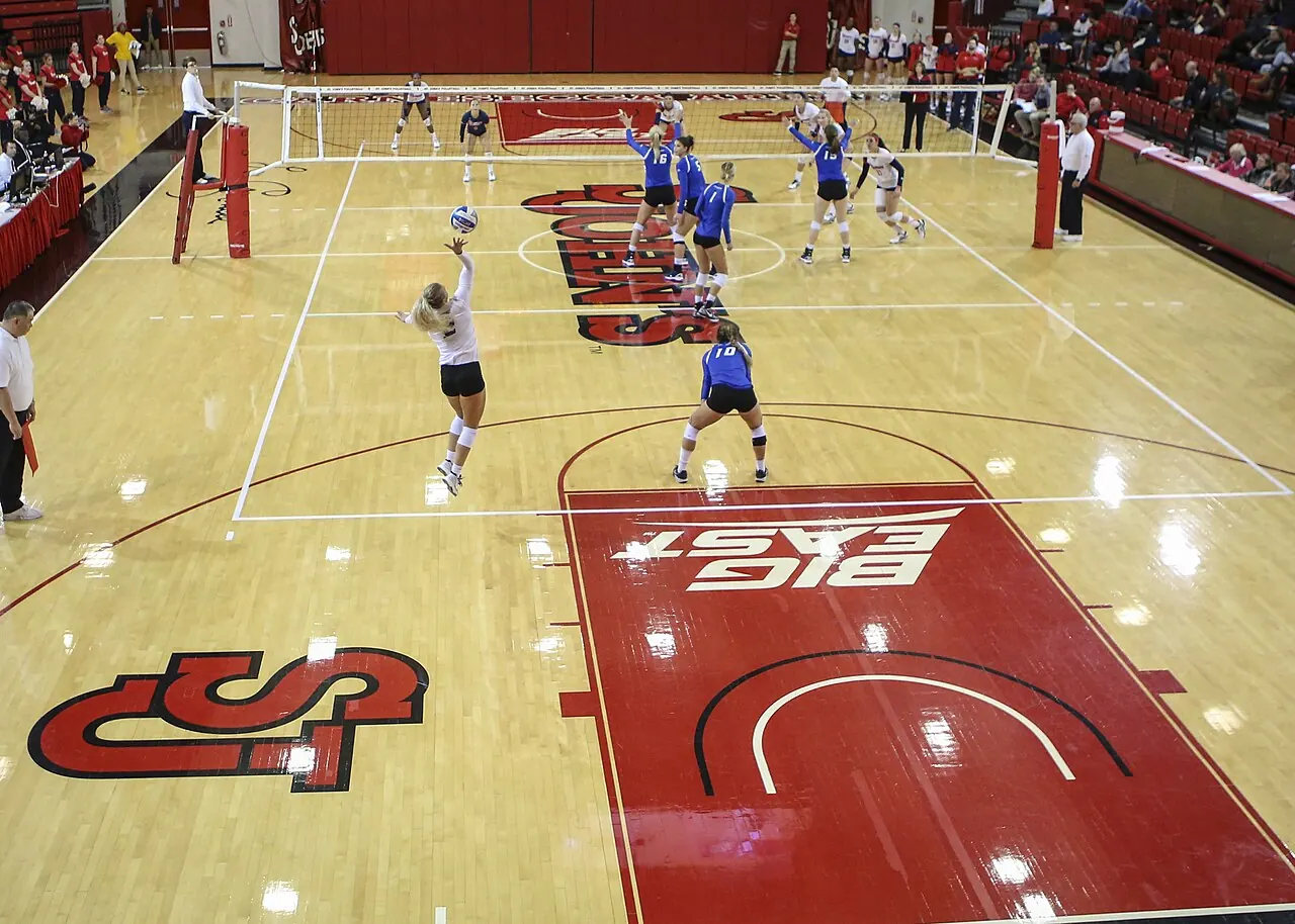 St. John’s and Creighton volleyball players facing each other across the net at Carnesecca Arena.