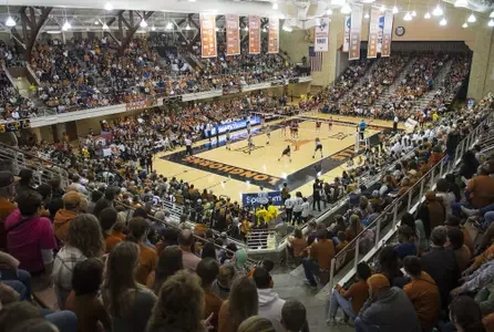 Elevated view of a volleyball court and crowded seating inside Gregory Gym